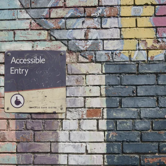 Brick wall with a sign reading "Accessible Entry"